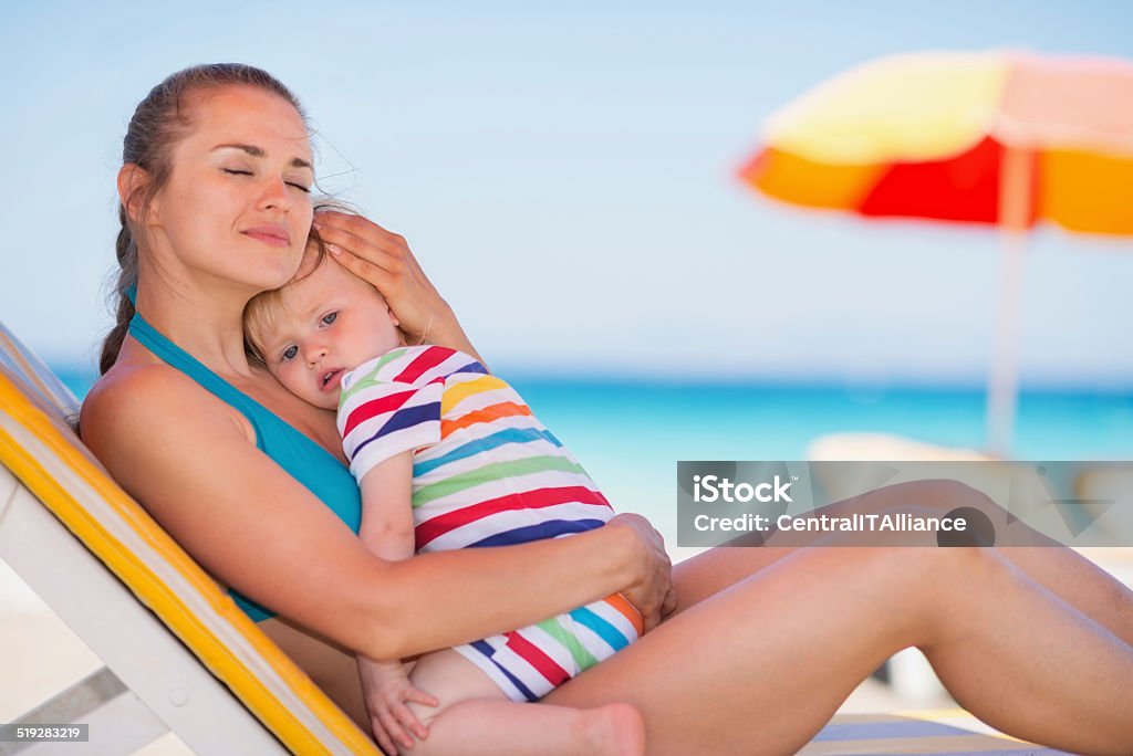 Tranquilo madre con bebé en el sol abrazar - Foto de stock de Abrazar libre de derechos