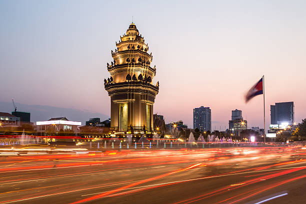 Sunset over Phnom Penh Traffic rush around the Independence monument, with its Khmer architecture style, in Phnom Penh, Cambodia capital city. Blurred motion archived with long exposure. cambodian culture stock pictures, royalty-free photos & images