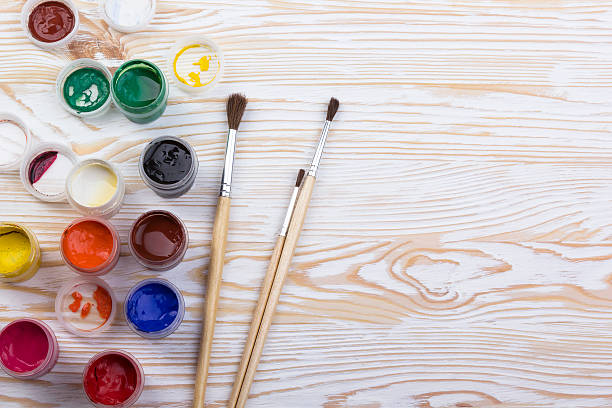 istock Gouache paints and brushes on wooden backgound 519307540
