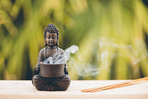 Buddha figurine with incense Buddha figurine with incense, selective focus  tibet photos stock pictures, royalty-free photos & images