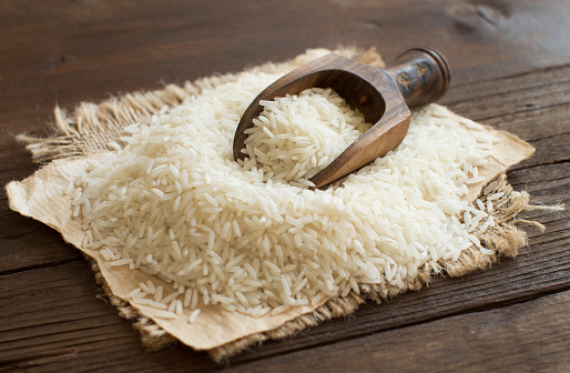 Pila de materias primas arroz Basmati con una cuchara photo