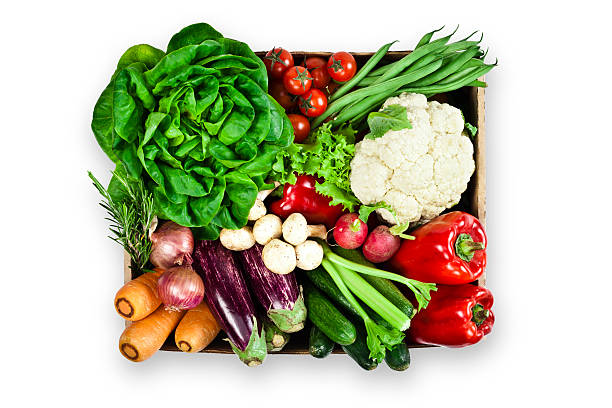 Crate filled with assortment of organic vegetables on white backdrop