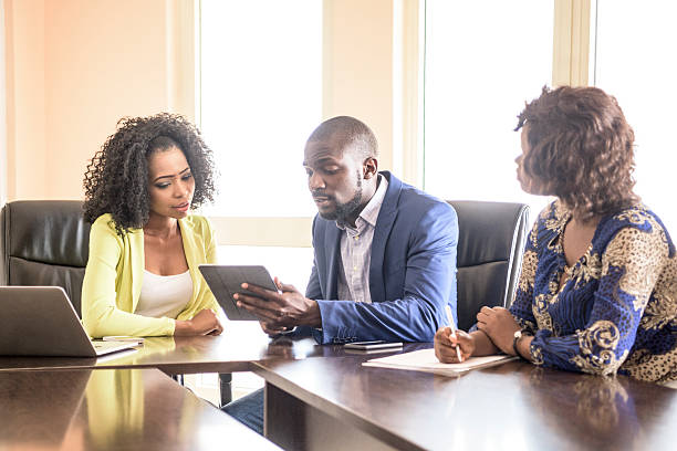 Three Nigerian colleagues in business meeting with tablet