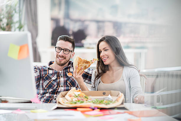istock Man and woman in the office having a pizza 519315788