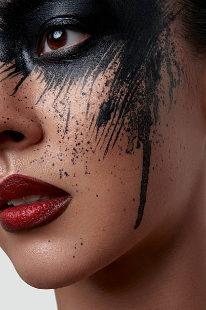 istock Closeup Portrait of Model with black Paint on her Face 519316626