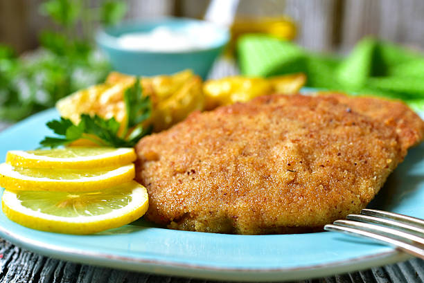 vienés milanesa en un azul placa. - viennese schnitzel fotografías e imágenes de stock