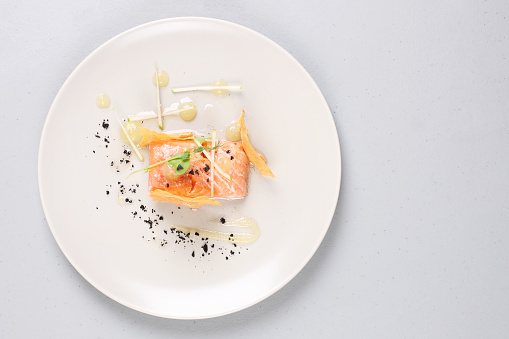 Smoked salmon with herbs, faked salmon roe. Sauce cooked by molecular gastronomy technic.