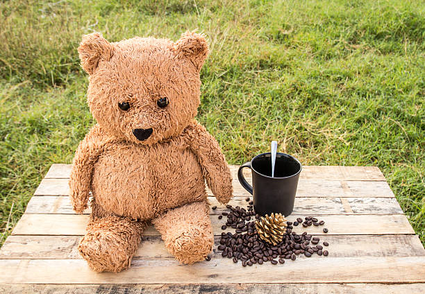 istock Teddy bear and coffee on wooden table 519319770