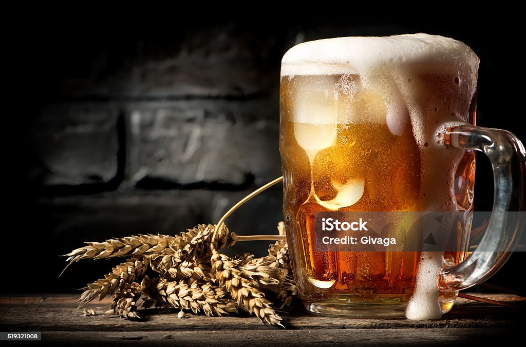 Beer near brick wall Light beer and wheat near brick wall Beer - Alcohol Stock Photo