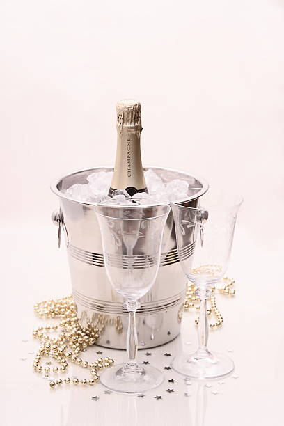istock Champagne bottle in cooler, two glasses 519327287
