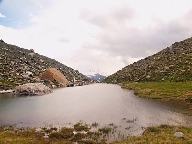 First snow in mountains. Autumn lake in Alps mirror level