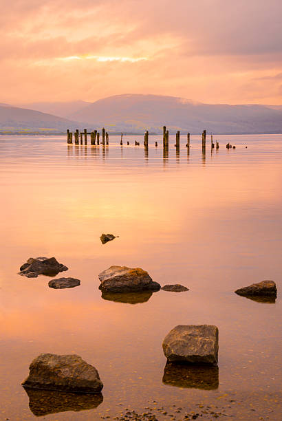 ロックロモンドの桟橋と山々に沈む夕日 - loch lomond loch ben lomond scotland ストックフォトと画像