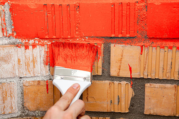istock Paint brush with red color on brick wall 519328051