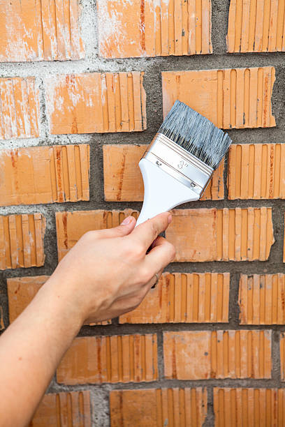 istock Human hand starting to paint brick wall 519328055