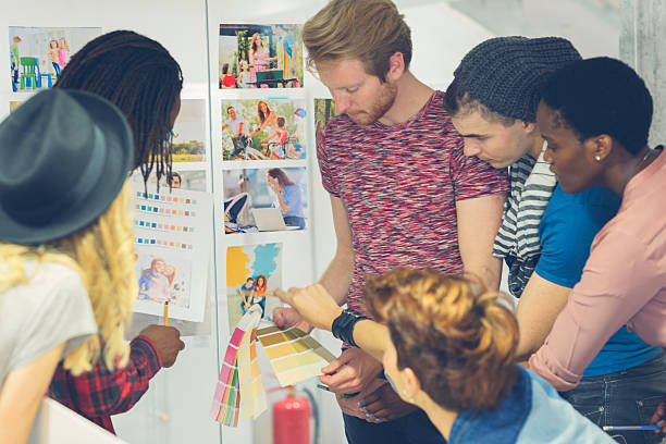 istock Multi-ethnic Creative Young Designers Team standing and looking at images. 519328837