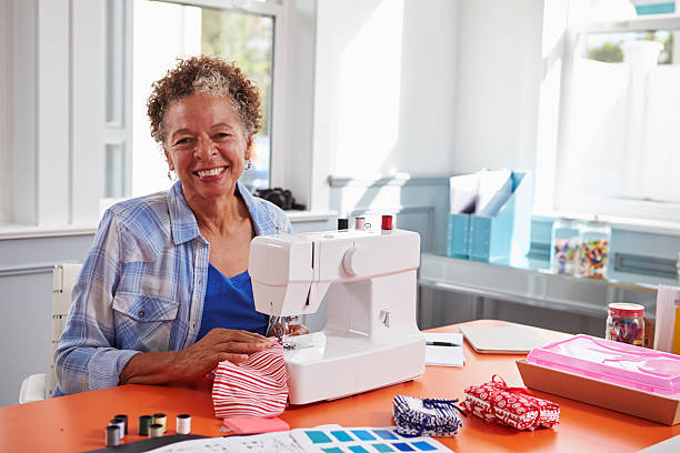 istock Senior black woman using a sewing machine looking to camera 519329770