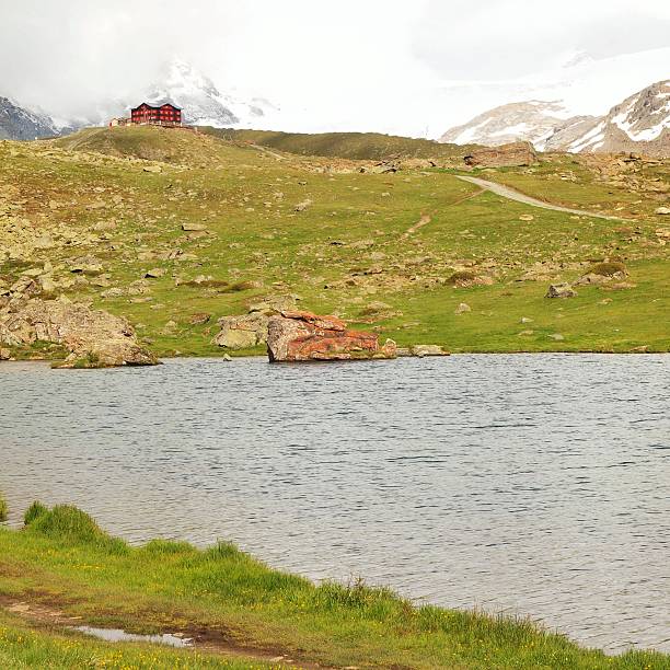 First snow in mountains. Autumn lake in Alps mirror level.