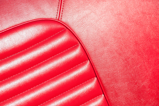 luxurious red leather classic car interior closeup in sunlight