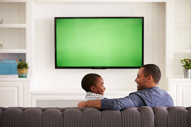 istock Father and son watching TV looking at each other, 519331548