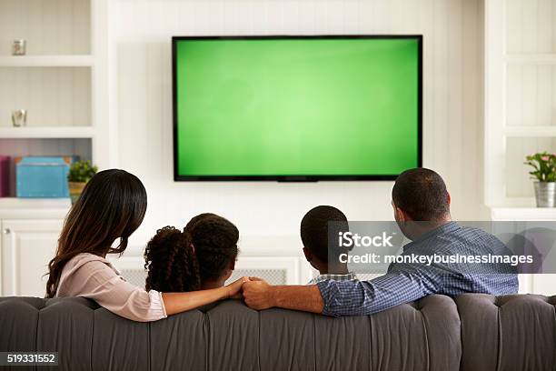 Eltern Und Ihre Beiden Kinder Schauen Zu Hause Gemeinsam Fern Stockfoto und mehr Bilder von Fernsehen