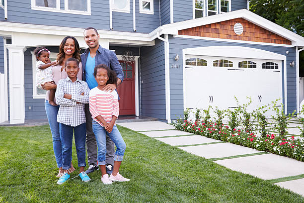 feliz familia negro de pie fuera de su casa - family houses fotografías e imágenes de stock