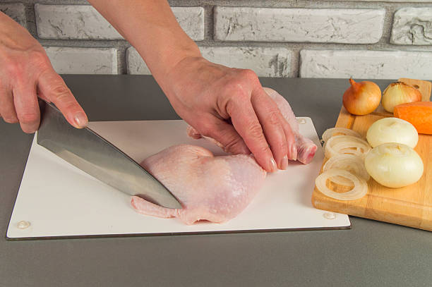 cucina chiken. femmina mano tagliato con un coltello. cipolle, carote - preparation meat single object female foto e immagini stock