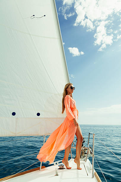 femme dans un paréo yachting ses voiles blanches de voyage de luxe - women sarong beach white photos et images de collection