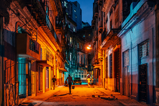 Havana, Cuba - March 18, 2015: Man walk on a  dark Street of Havana, Cuba at night.