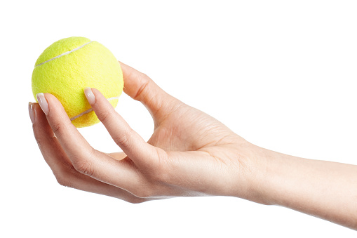 Female hand holding a tennis ball isolated on white background.