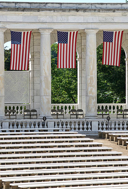 U.S. Flags, Seats at Memorial Amphitheater, Arlington National Cemetery Arlington, Virginia, USA - May 24, 2015: U.S. flags hang inside the Memorial Amphitheater at Arlington National Cemetery during Memorial Day weekend events. memorial amphitheater stock pictures, royalty-free photos & images