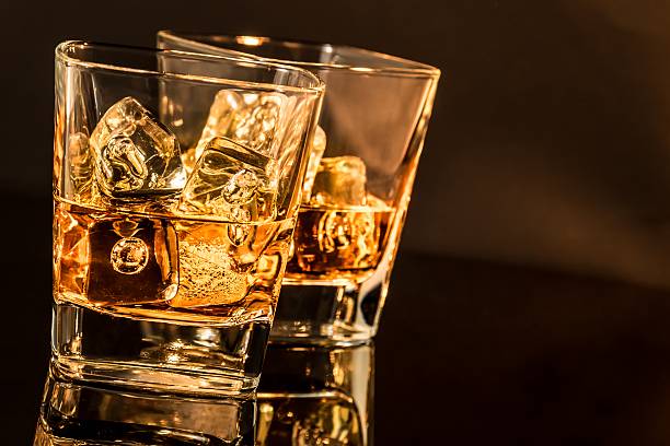 istock two glasses of whiskey, warm atmosphere 519344254