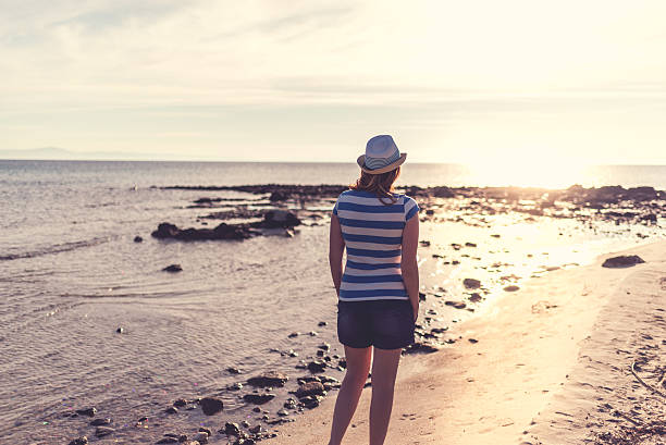 istock Woman on the beach at sunrise 519345646