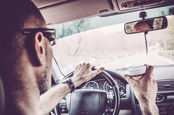 istock Man driving his Car and drinking take away coffee 519357360