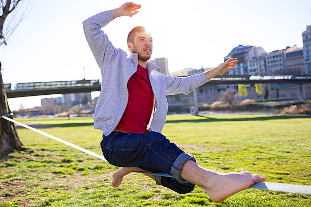 istock Handsome young man walking on slackline in the park. 519358402