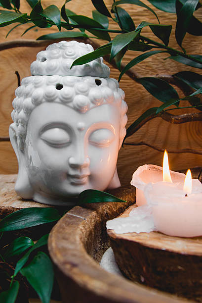 istock Buddha in meditation, burning candle, ruscus flowers. Zen concept 519358788