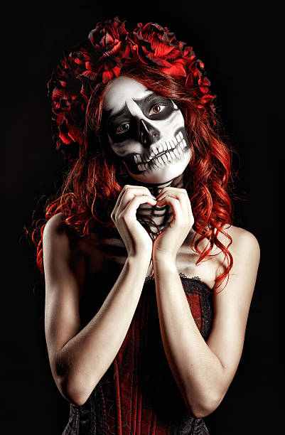istock Young woman with calavera makeup (sugar skull) making heart sign 519361707
