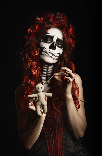 istock Young woman with calavera makeup (sugar skull) piercing voodoo doll 519361727