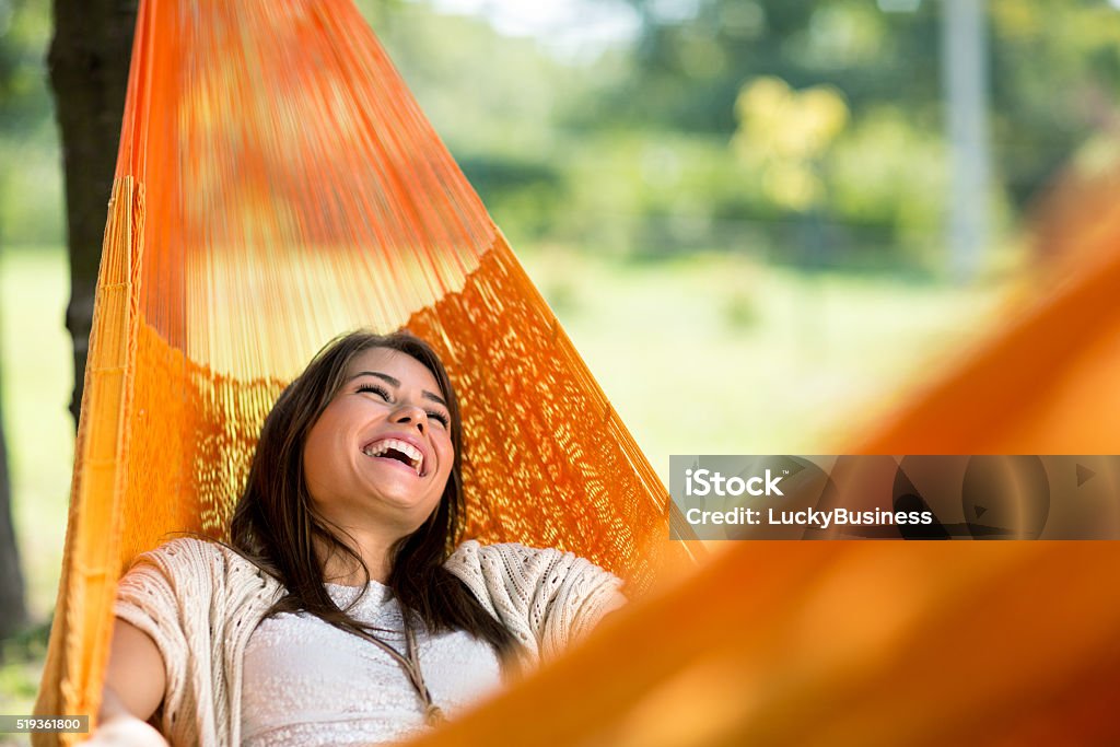 Cheerful girl enjoy in hammock Cheerful girl enjoy in orange hammock outdoor Hammock Stock Photo