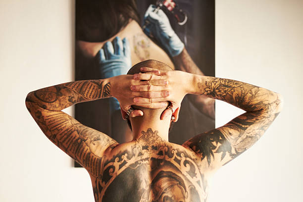 Proud of my identity The back of a male with tattoos along his back with his hands on his head chest tattoos for men designs stock pictures, royalty-free photos & images