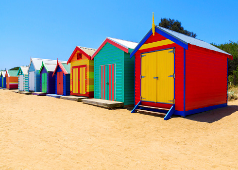 A row of colourful multi-coloured wooden beach huts at Brighton Beach, Melbourne, Victoria State, Australia