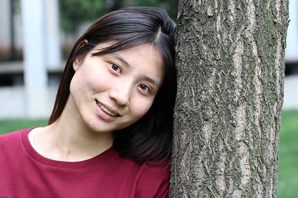 istock Happy Chinese Girl Leaning on the Tree 519364070