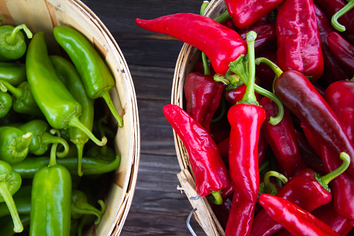 An overhead shot of red and green chile peppers in bushel baskets at a farmers' market.  Shot in Santa Fe, NM.