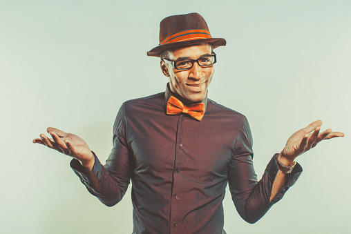 Happy african american male dressed in hipster style, gesturing with hands