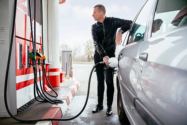 At Gas Station Man At Gas Station Filling Up Her Car With Petrol refueling stock pictures, royalty-free photos & images