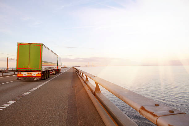 Truck i sunrise Truck on the road over a large bridge in Denmark - Scandinavia, oresund bridge stock pictures, royalty-free photos & images