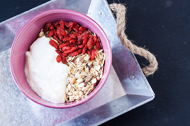muesli with yogurt and goji berry on a black background