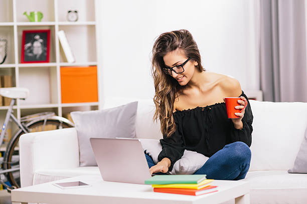 donna utilizzando il computer portatile a casa - laptop adult curtain business foto e immagini stock
