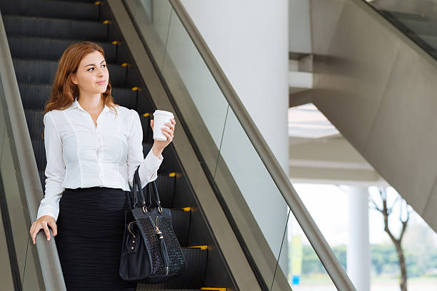 sair office building - escalator elevator women leaving - fotografias e filmes do acervo