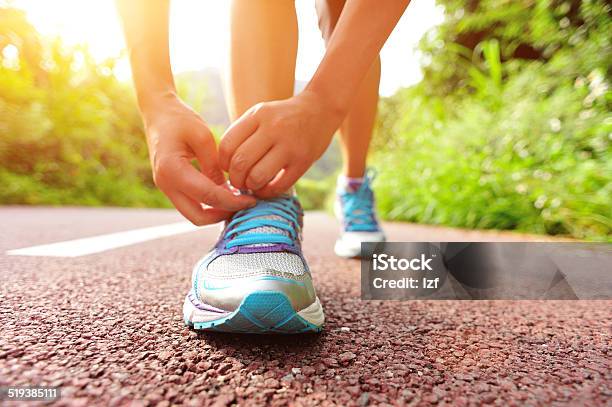 Woman Runner Tying Shoelaces On Trail Stock Photo - Download Image Now - Adult, Adults Only, Asian and Indian Ethnicities