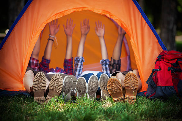 Happy Campers Lying in a Tent Group of young campres lying down in a tent with their hands up dome tent photos stock pictures, royalty-free photos & images